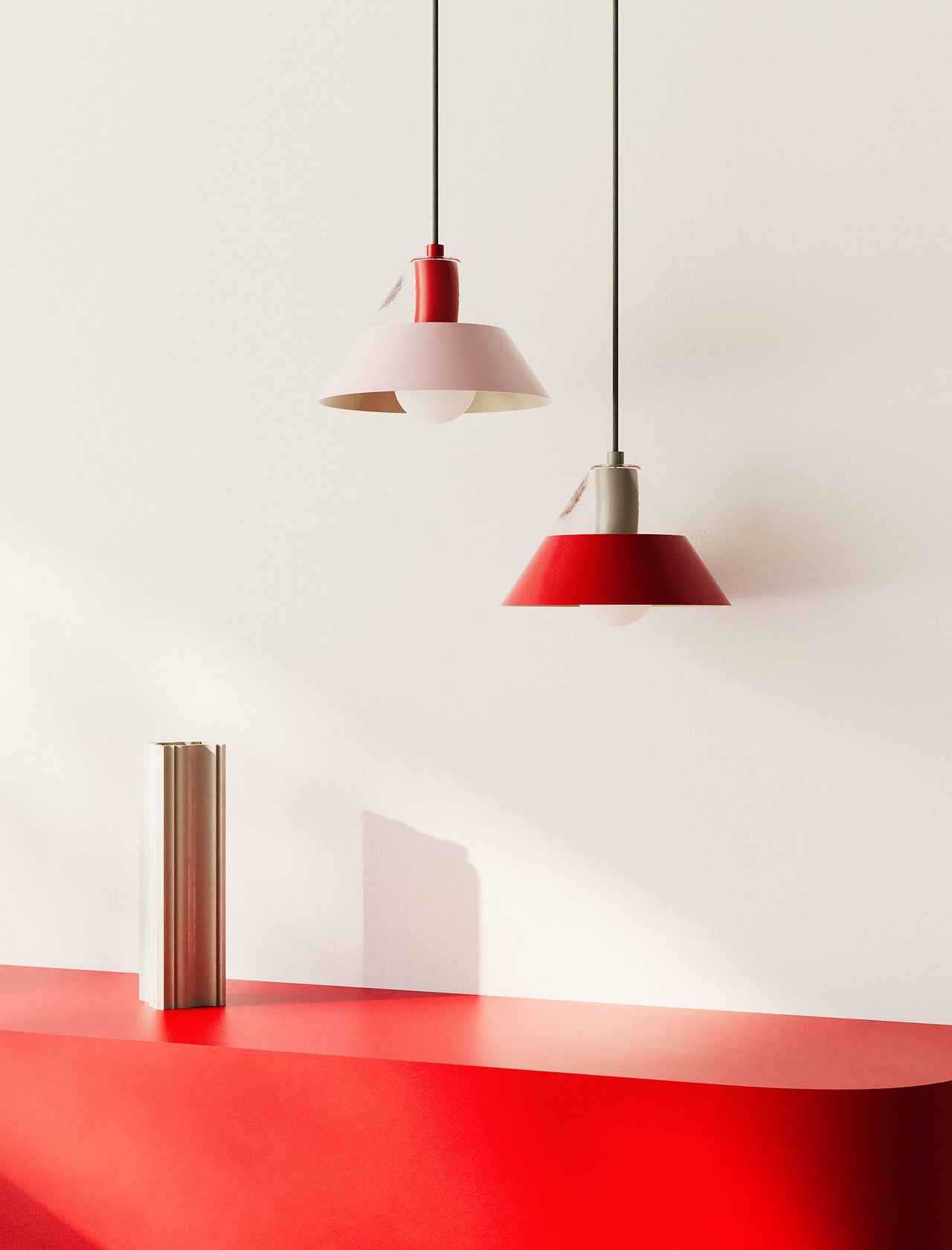 FIFTY FIFTY Lamp with red and pink metal shades hanging over a red table in a minimalist setting.