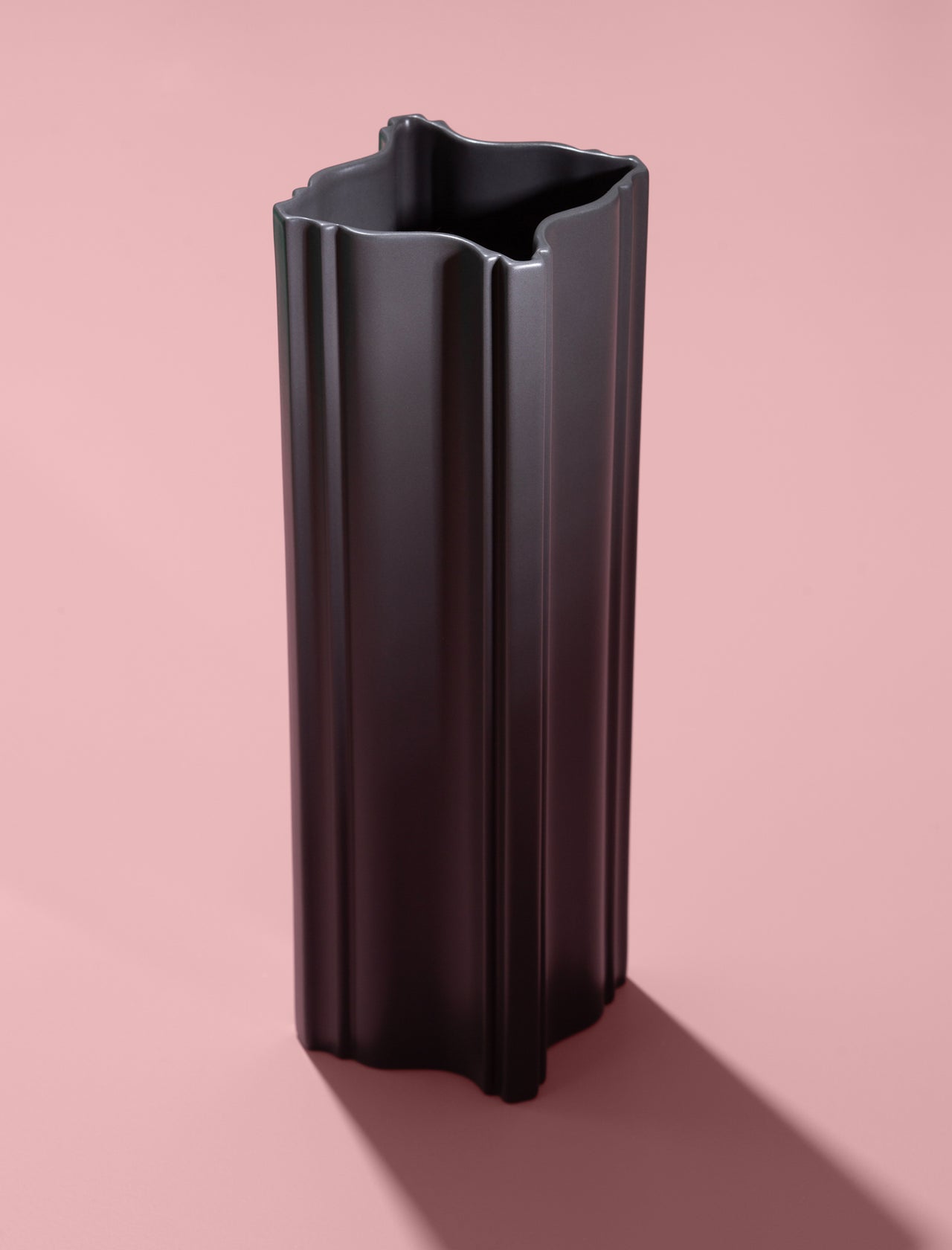 FIFTY FIFTY Lamp with a pink metal shade and red fixture hanging above a red surface and minimalist decor.