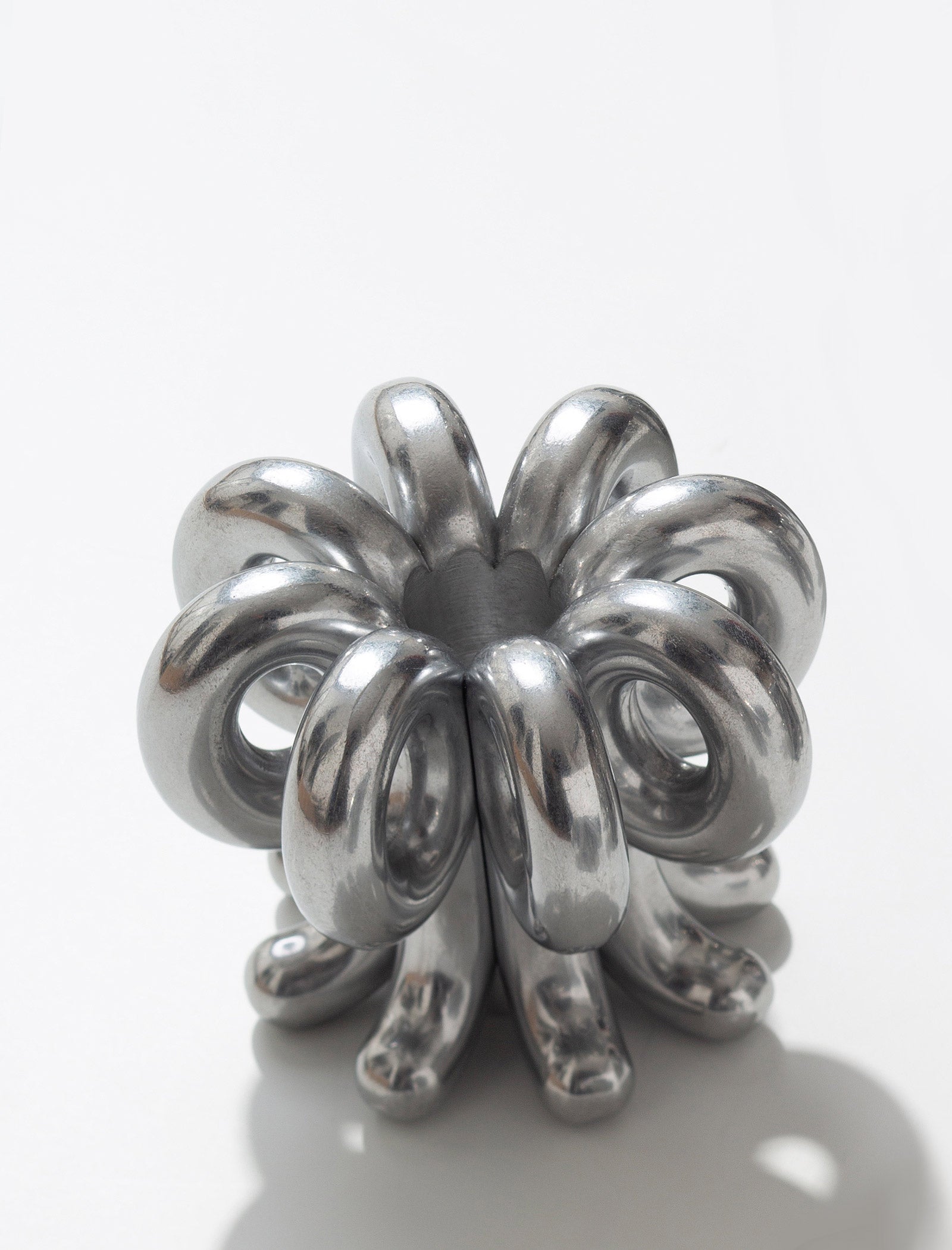 DIGIT NINE Candlestick made of polished aluminum with a unique looped and sculptural design for modern decor.